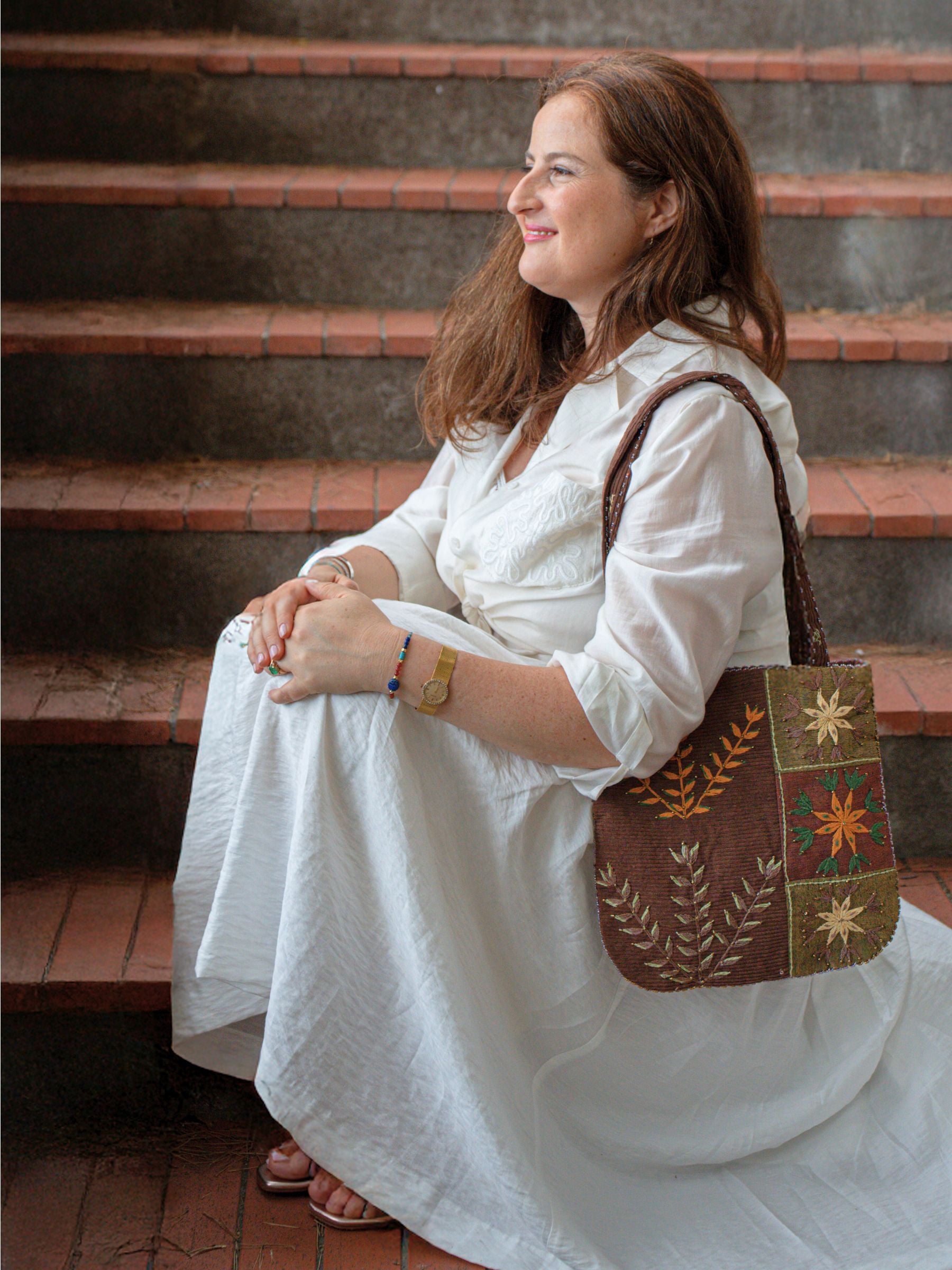 Sac Jardin Velours Nilazur porté par Princesse Fawzia, design bohème chic aux motifs floraux et velours côtelé.