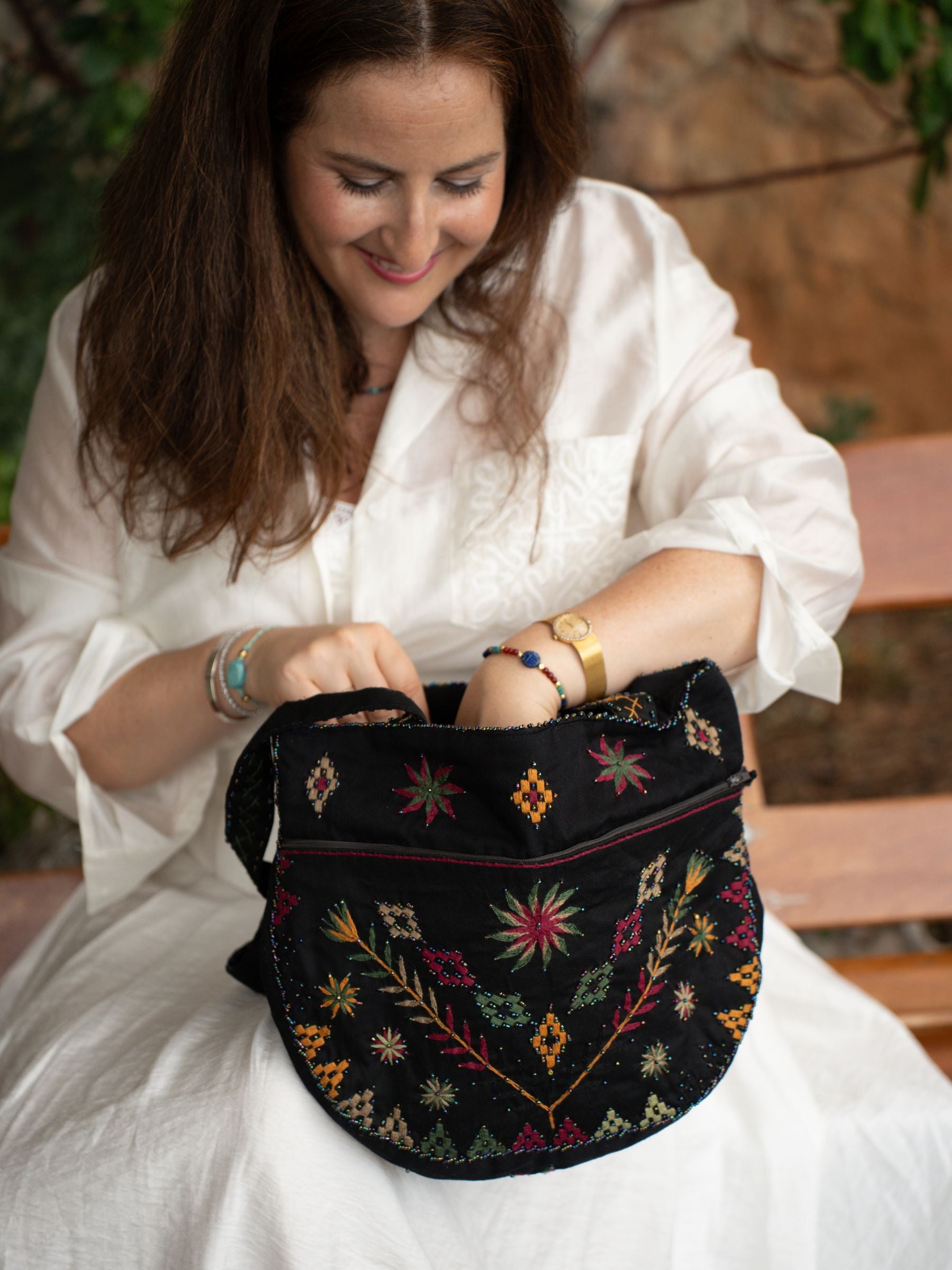 Détail du sac brodé Black Garden Nilazur avec motifs floraux en fil terracotta et vert sur toile noire, perles Miyuki délicates