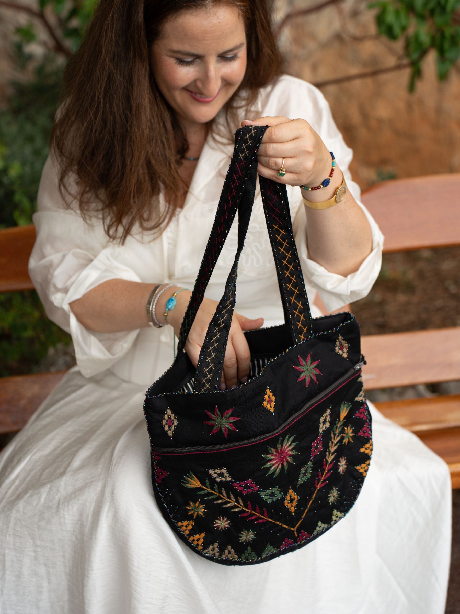 Détail du sac brodé Black Garden Nilazur avec motifs floraux en fil terracotta et vert sur toile noire, perles Miyuki délicates