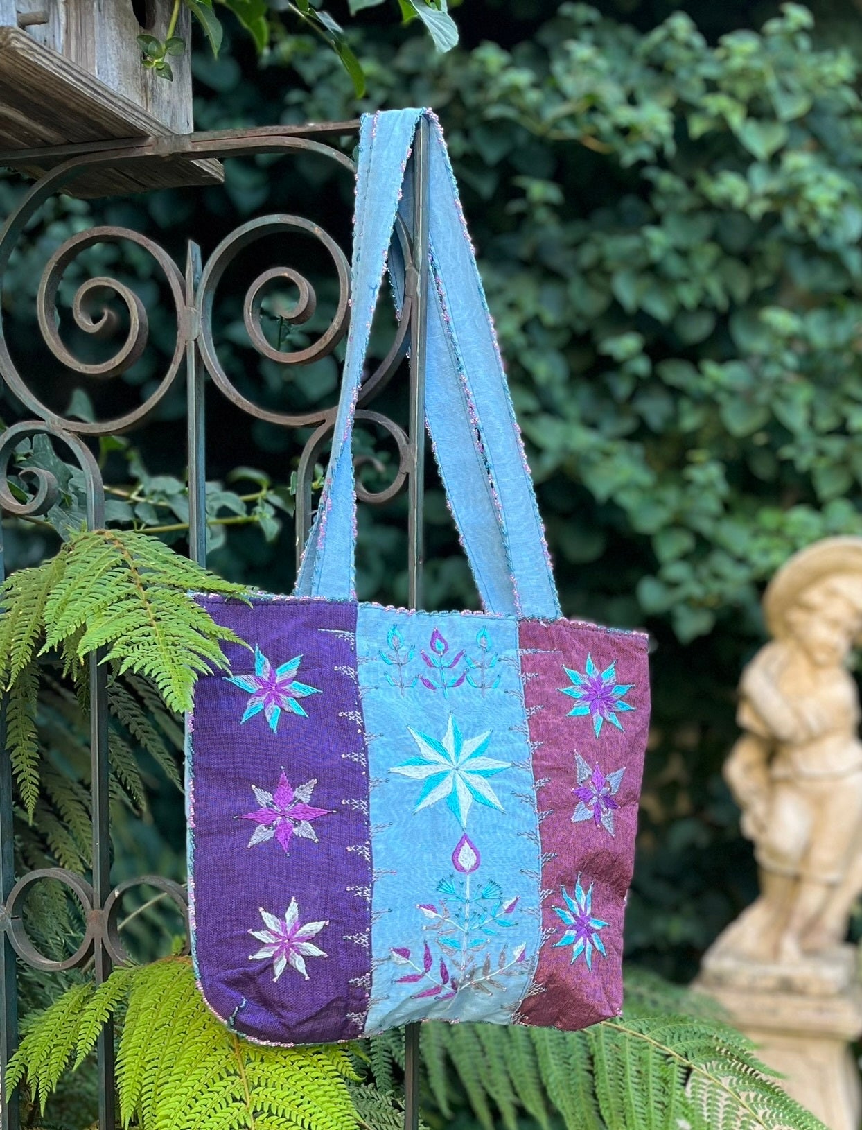 Detalle de bolso artesanal Nilazur, bordado a mano con motivo de lavanda del desierto en tonos turquesa y lavanda, decorado con perlas Miyuki