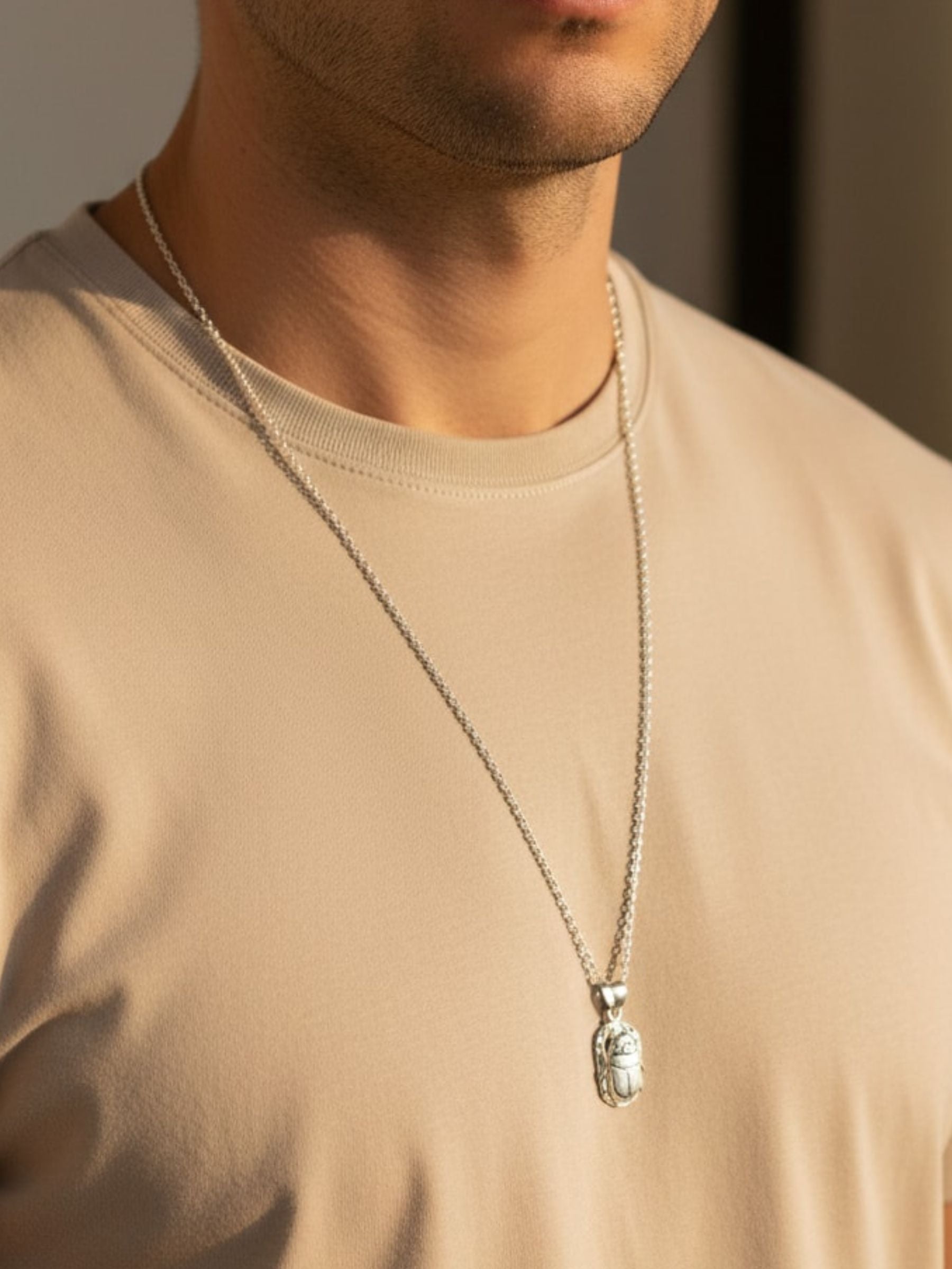 Homme en t-shirt portant le collier scarabée égyptien en argent 925, bijou porte-bonheur et symbole de renouveau
