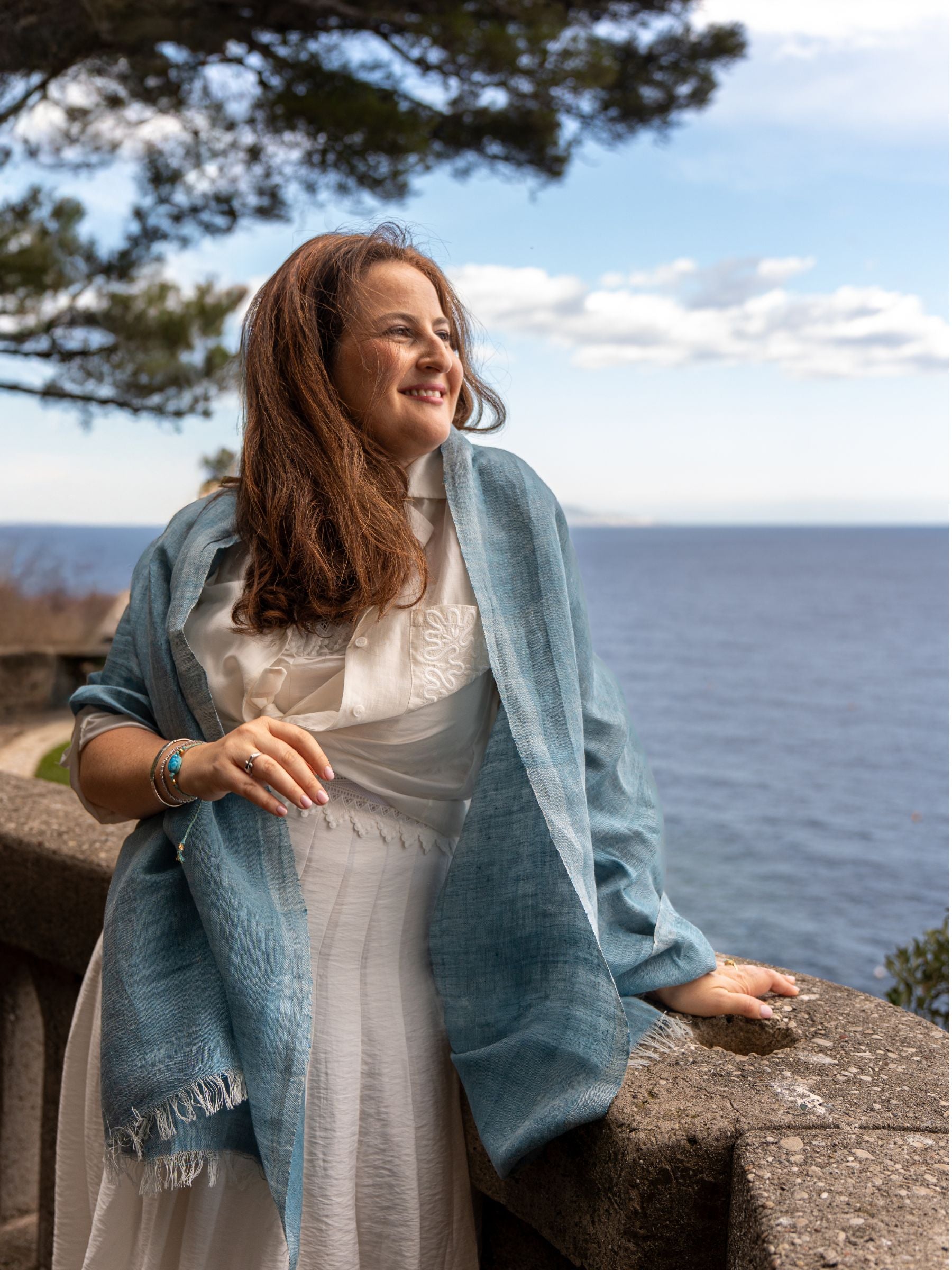 Femme portant une etole bleu en lin et coton au bord de la mer